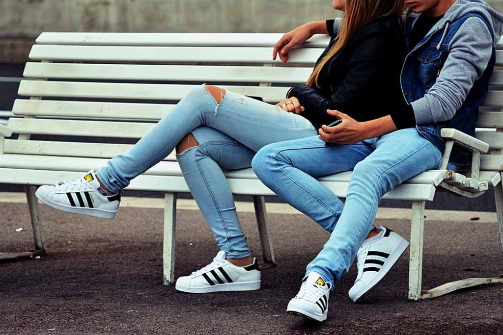 young couple waiting on a bench