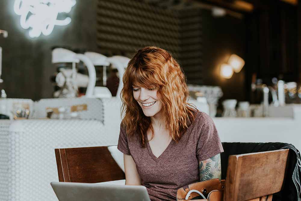 cafe girl happy looking at laptop probably her STD results